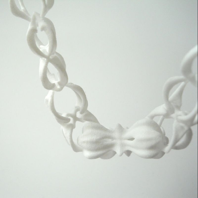 3D printed necklace with bone-like chain links and a bigger piece in the middle of it.